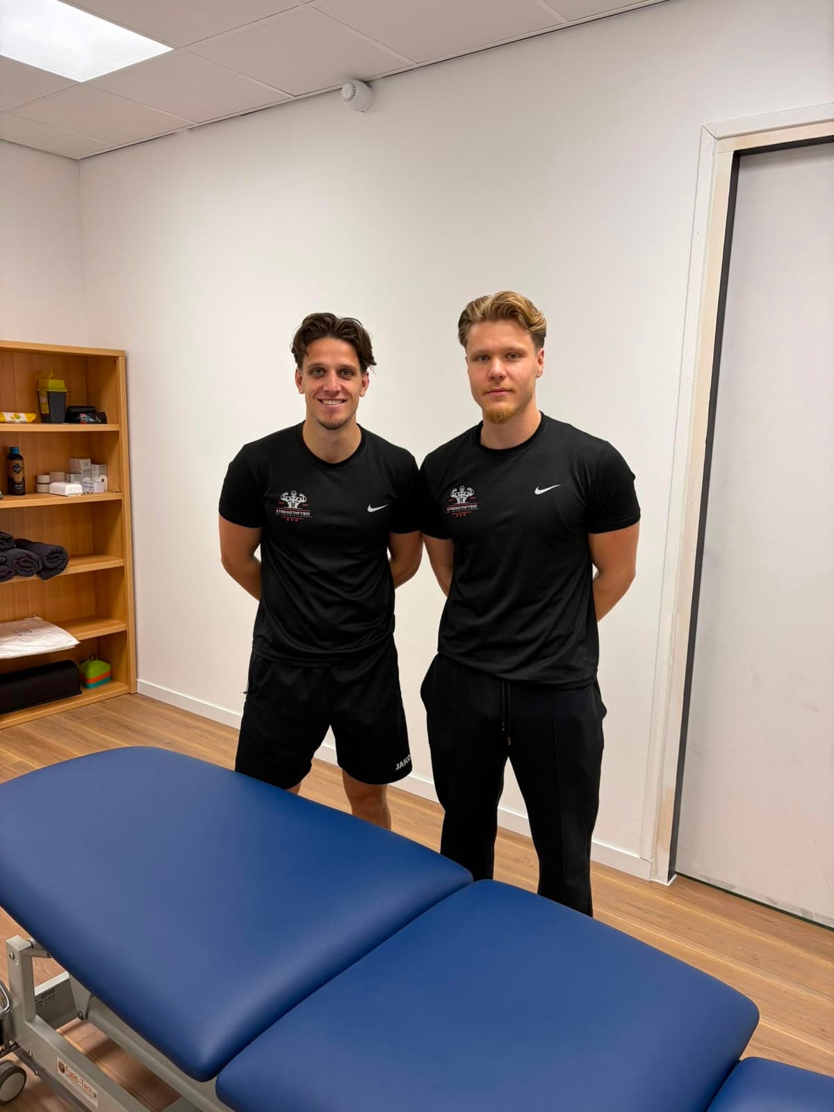 Fysiotherapeuten Jarno Deen en Erdem Benlisoy in de behandelkamer van StrengthFysio
